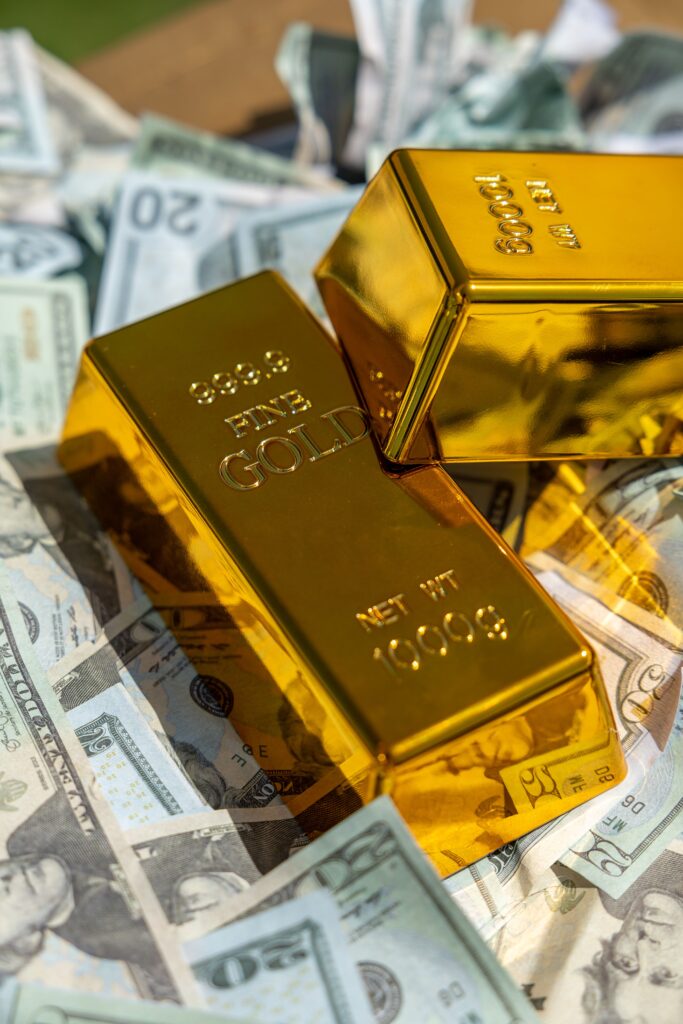 Gold bars on US dollar banknotes illustrating global gold ETF investment and safe haven assets