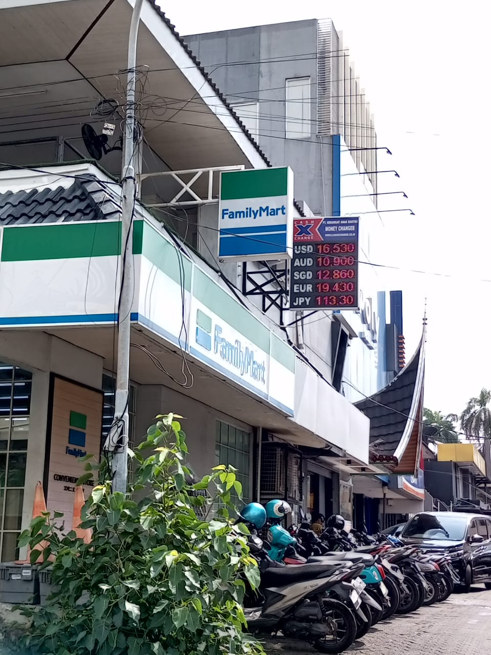 Cash X Change city money changer with visible exchange rate board in an urban commercial area in Indonesia